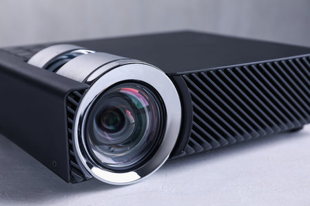 One modern video projector on white table, closeup
