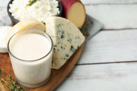 Different dairy products and thyme on white wooden table, closeup. Space for text
