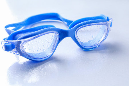 Swimming goggles with water drops on light surface, closeupの写真素材