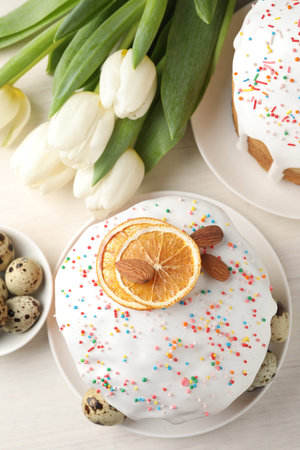 Beautiful Easter cakes, eggs and tulips on white table, flat lay