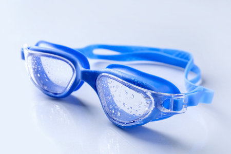 Swimming goggles with water drops on light surface, closeupの写真素材