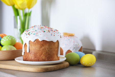 Tasty Easter cake and painted eggs on wooden table, closeup