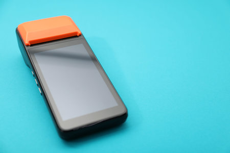 One payment terminal on light blue background, closeup. Space for text