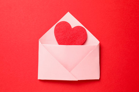 Love. Envelope with decorative heart on red background, top view