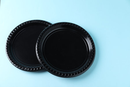 Plastic packaging. Black plates on light blue background, above view with space for text