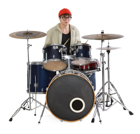 Teenage boy in glasses and hat with drumsticks learning how to play drums on white backgroundの写真素材