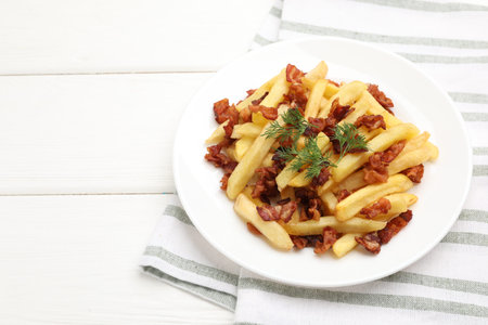 Delicious French fries with bacon on white wooden table, closeup. Space for text