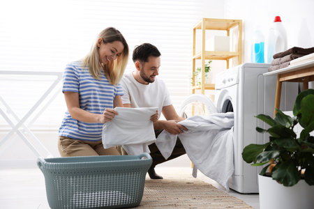 Couple doing laundry together at home. Domestic choresの写真素材