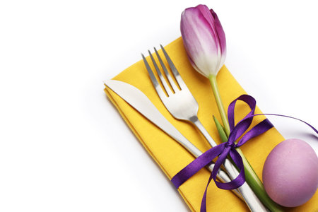 Easter celebration. Festive table setting with floral decor and painted egg isolated on white, top...