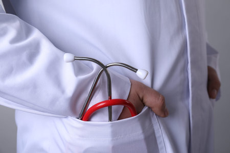 Doctor with stethoscope on grey background, closeupの写真素材