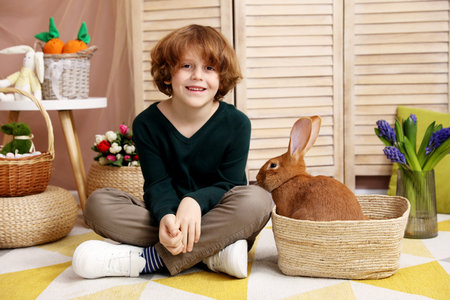 Little boy with cute Easter bunny in wicker basket indoors