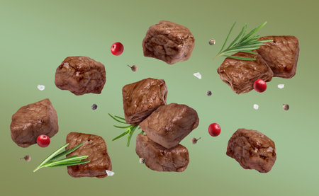 Roasted beef pieces with rosemary and spices flying in air on color gradient backgroundの写真素材