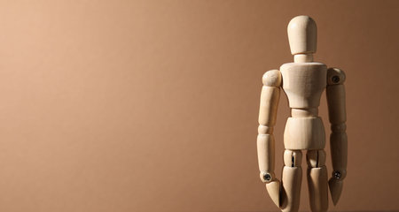 One wooden mannequin on beige background, closeup. Space for text