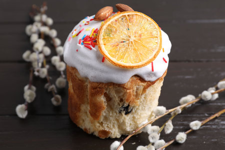 Delicious Easter cake and willow branches on wooden table, closeup