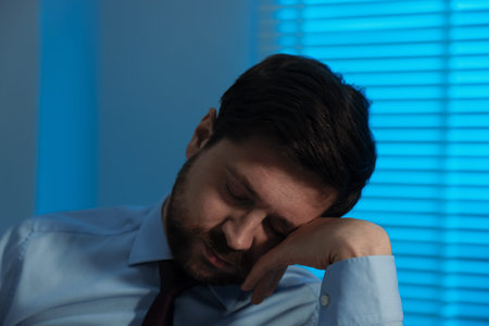 Unhappy businessman feeling fatigue in office at nightの写真素材