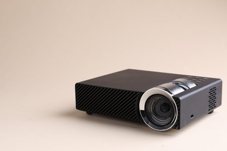 One modern video projector on beige background, space for text
