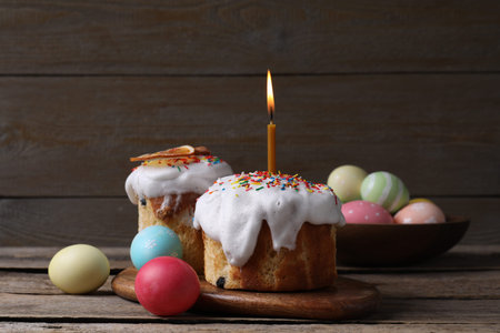 Delicious Easter cakes with painted eggs on wooden table