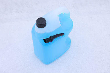 Canister of antifreeze on snow outdoors, above view