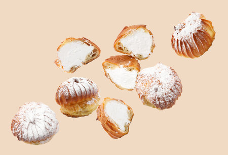 Profiteroles with cream flying on beige background
