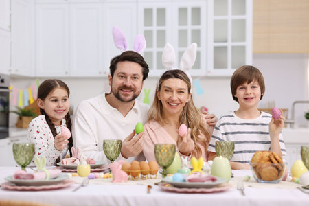 Easter celebration. Family with painted eggs at served table in kitchen