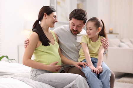 Pregnant woman, her husband and daughter at home