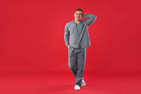 Man in stylish pajamas on red backgroundの写真素材