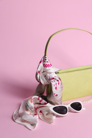 Stylish handkerchief, sunglasses, necklace and bag on pink background, closeupの写真素材