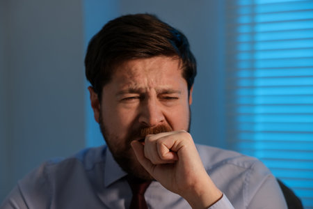 Unhappy businessman feeling fatigue in office at nightの写真素材