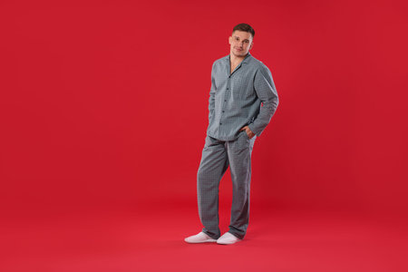 Man in stylish pajamas on red backgroundの写真素材