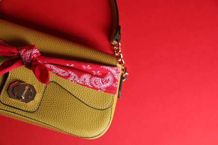 Stylish handkerchief and bag on red background, top view. Space for textの写真素材