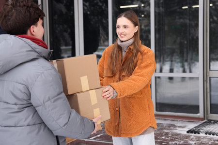 Woman receiving parcels from delivery man outdoorsの写真素材