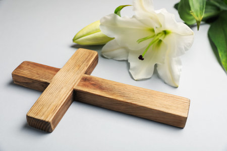 Easter. Wooden cross and beautiful lily flower on gray background, closeupの写真素材