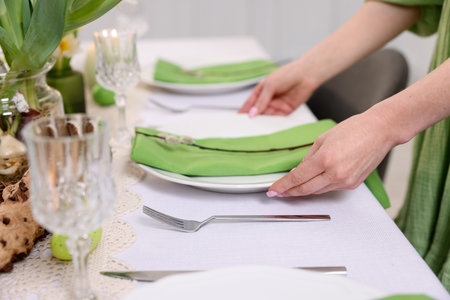 Woman setting festive table for Easter celebration at home, closeupの写真素材