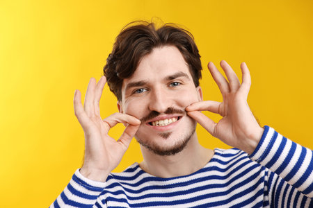 Handsome man with mustache on orange backgroundの写真素材