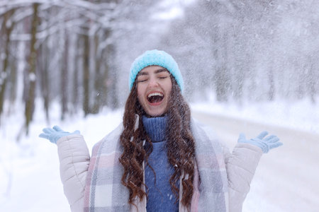 Beautiful woman playing with snow in winter forestの写真素材