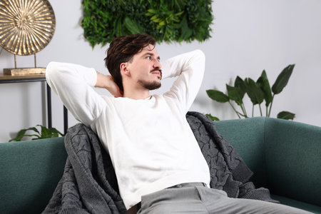 Man having rest on sofa at homeの写真素材