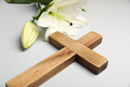 Easter. Wooden cross and beautiful lily flower on gray background, closeupの写真素材