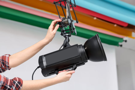 Woman with professional lighting equipment in photo studio, closeupの写真素材