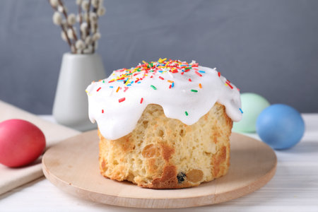 Delicious Easter cake, painted eggs and willow branches on white wooden table, closeup
