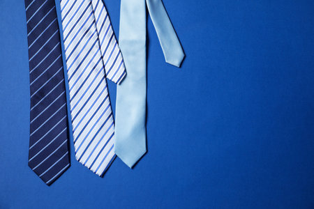 Different stylish ties on blue background, flat lay. Space for textの写真素材