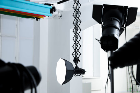 Professional lighting equipment hanging from ceiling in photo studio