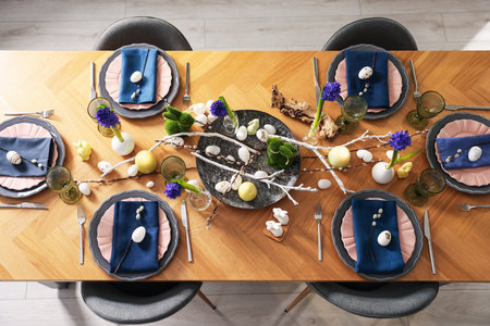 Easter celebration. Festive table setting with flowers and painted eggs indoors, flat lay