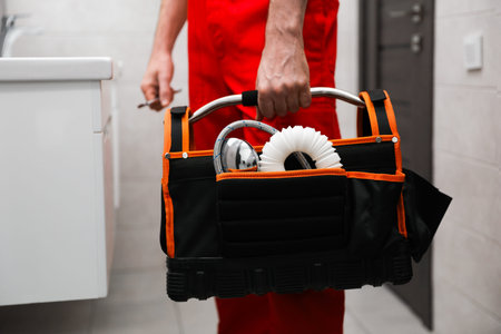 Plumber with black toolbox in restroom, closeupの写真素材