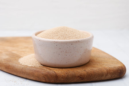 Dry yeast in bowl on white table, closeupの写真素材