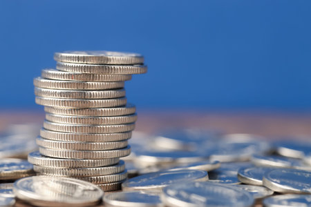 Stacked coins on table against blue background, closeup. Space for text