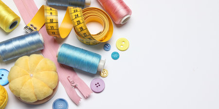 Flat lay composition with sewing supplies on white background. Space for text