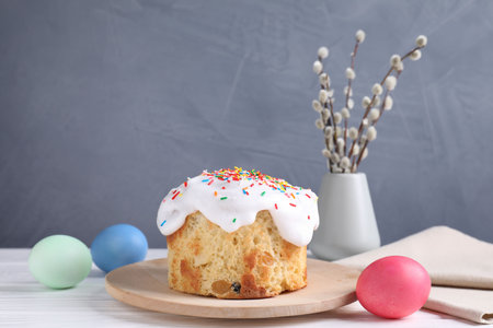 Delicious Easter cake, painted eggs and willow branches on white wooden table