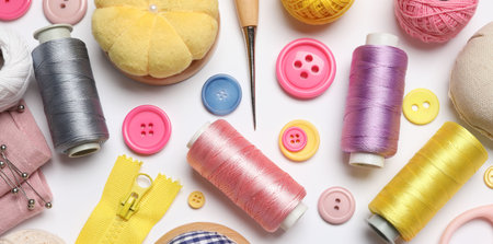 Different sewing supplies on white background, flat lay