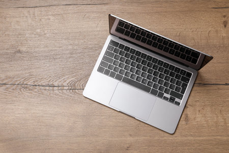 Modern laptop on wooden table, top view. Space for text