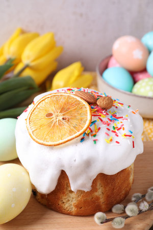 Delicious Easter cake, painted eggs, willow branches and tulips on table, closeup